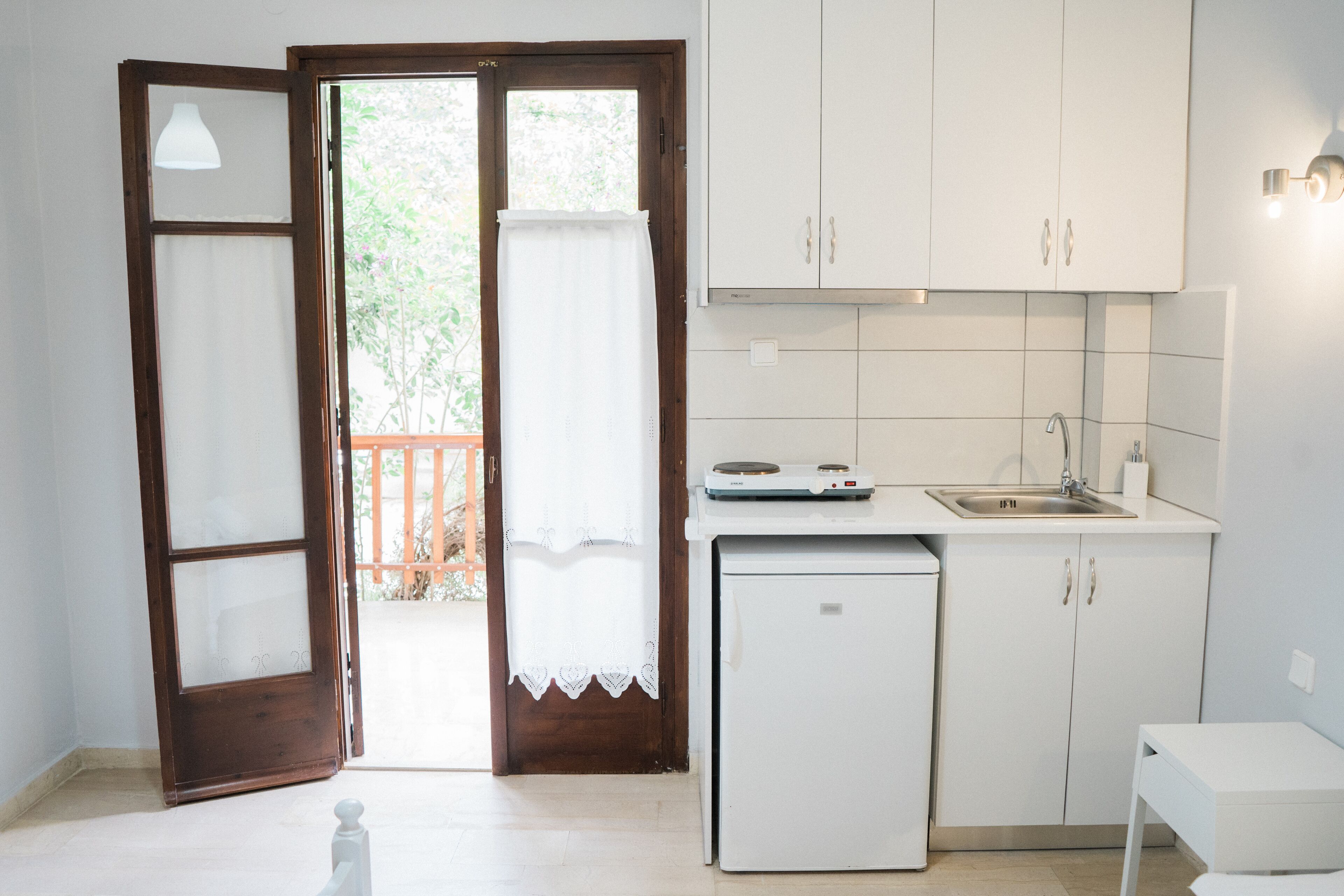 A compact kitchen with a refrigerator, sink, and cabinets.