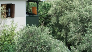 A house with a tiled roof, a balcony, and a view of the sea. - Afroditi Pansion (Lefkada)