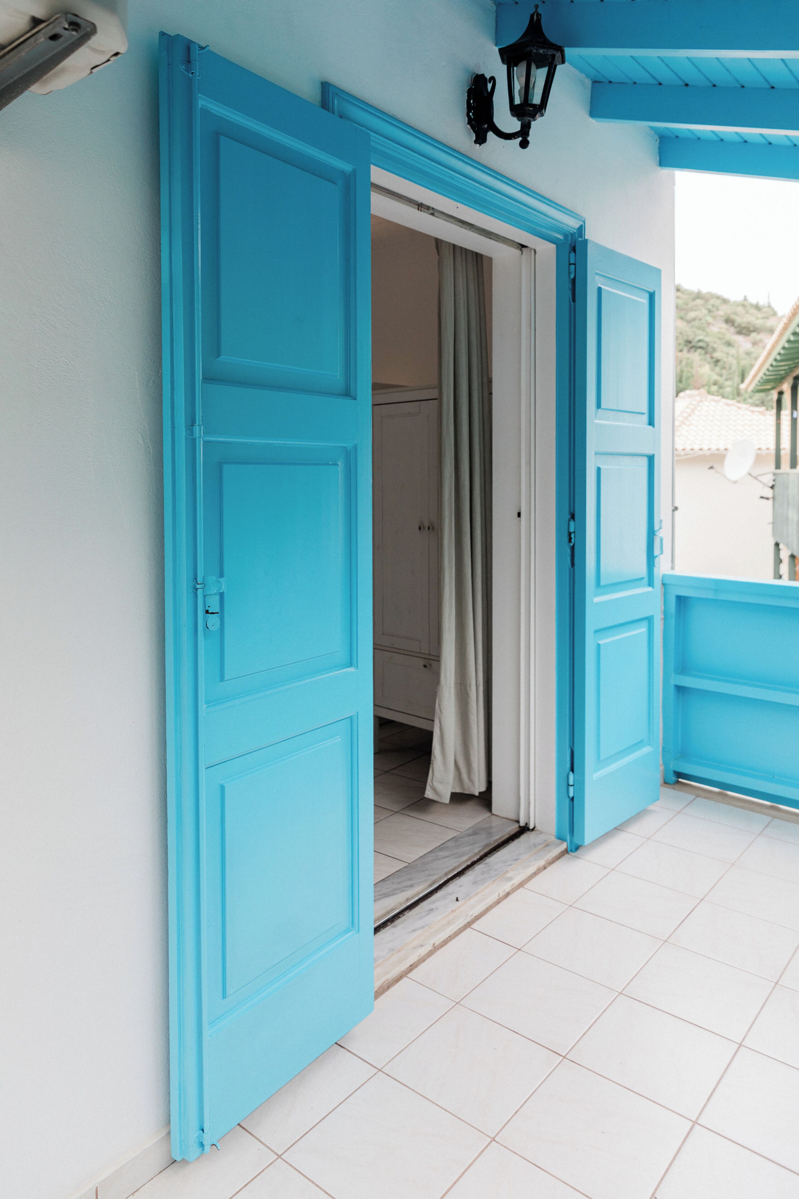 A room with a blue door, white walls, and a tiled floor.
