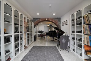 Relax and create in this serene space, featuring a grand piano and a curated collection of cameras.