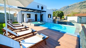 A modern outdoor pool area with lounge chairs and a pergola. - Perla Villas with Heated Pool (Apokoronas)