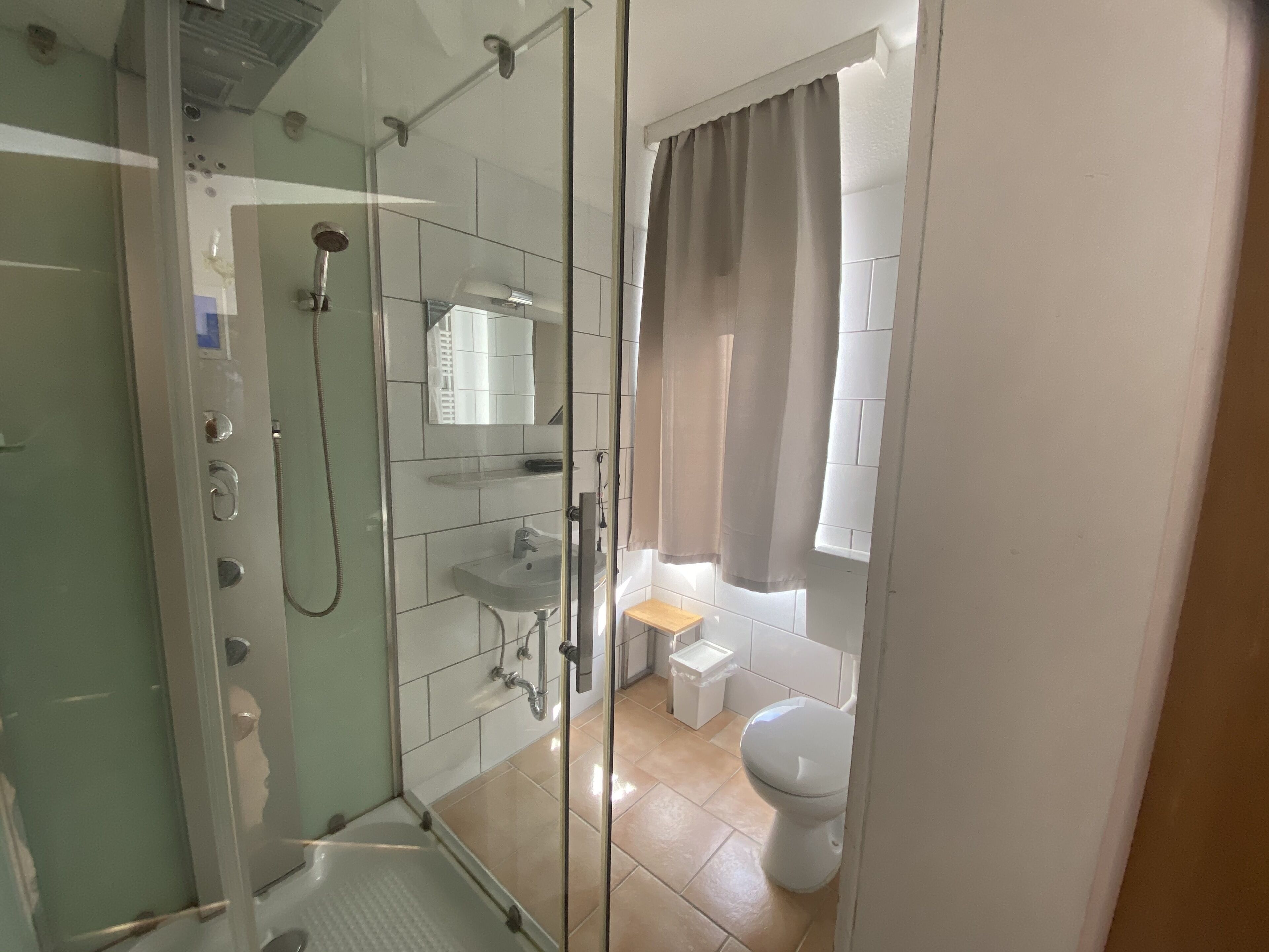 Un baño moderno con ducha de vidrio, lavabo e inodoro.