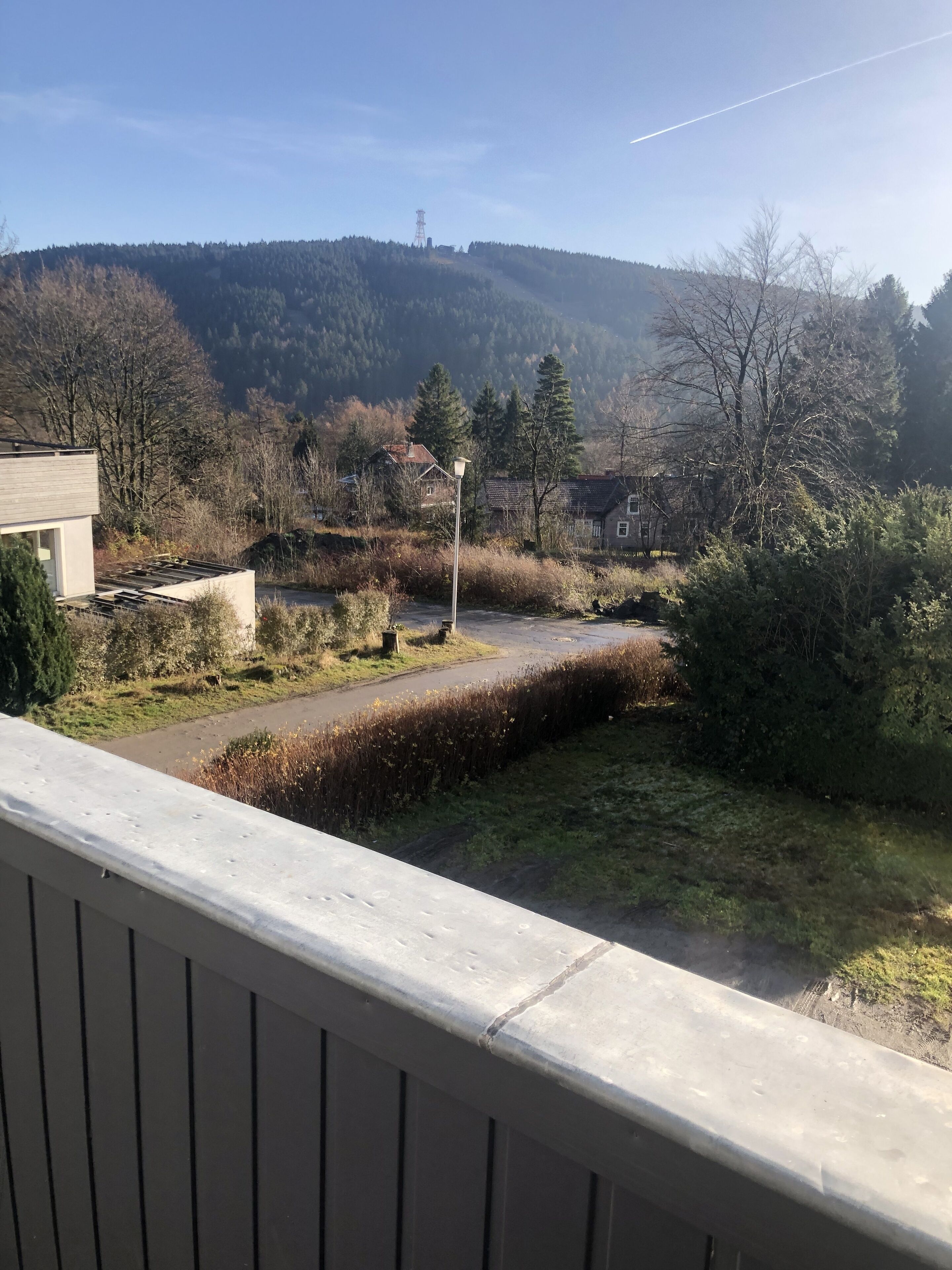 Un quartier résidentiel avec des maisons, une route asphaltée et une colline en arrière-plan.