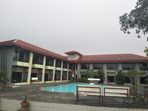 A hotel with a swimming pool, multiple balconies, and a red roof. - RoomQuest Chonburi Phanat Nikhom (Phanat Nikhom)