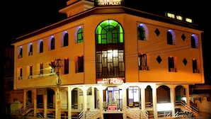 Un hotel con una entrada abovedada destacada y varios balcones.