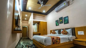 Un dormitorio con cama de madera, ventilador de techo, aire acondicionado y una mesita de noche.