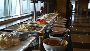 A buffet setup with various food items and utensils. - Barden Hotel (Siirt)
