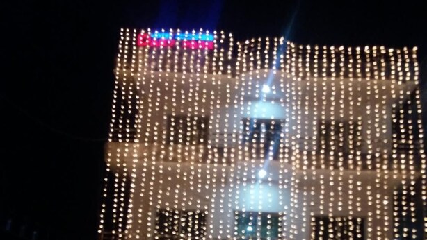 Un edificio de varios pisos decorado con numerosas luces colgantes.