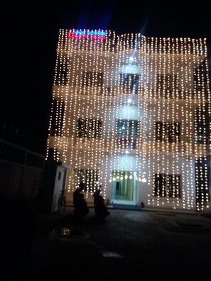Un edificio de varios pisos decorado con numerosas luces colgantes.