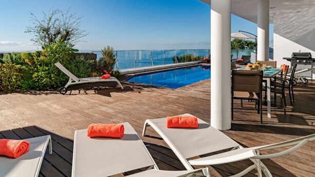 A poolside area with lounge chairs, a dining table, and a barbecue grill. - Fonte do Mar 1 - Four Bedroom Villa, Sleeps 8 (Caniço)