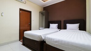 Een hotelkamer met twee bedden, een houten deur, een douche en een airconditioning.