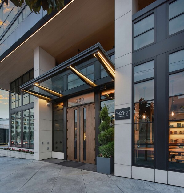 A modern hotel entrance with a glass canopy, a number '250' sign, and a 'canopy by Hilton' sign. - Canopy by Hilton San Francisco SoMa (San Francisco)
