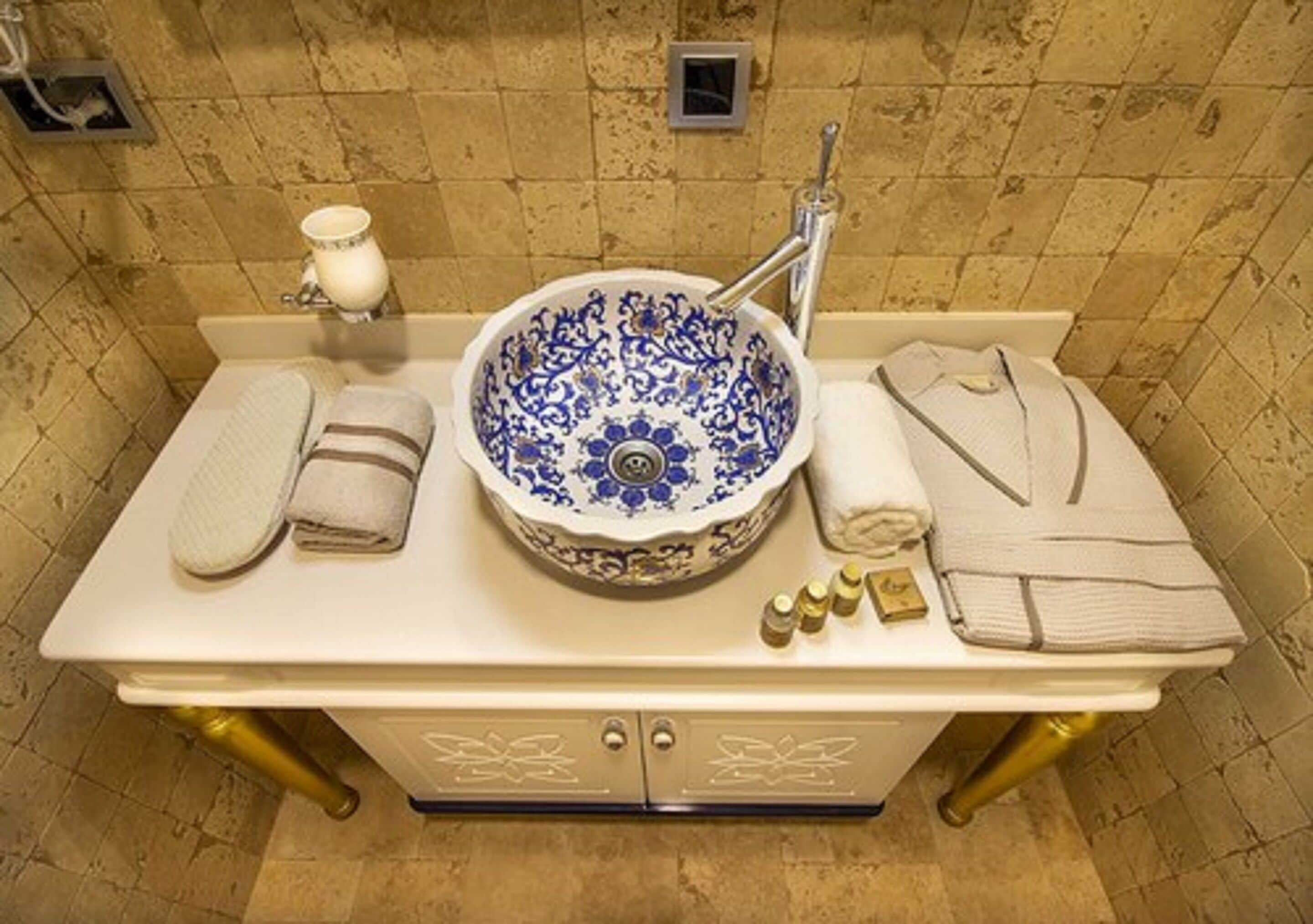A bathroom with a sink, towel rack, and toiletries.
