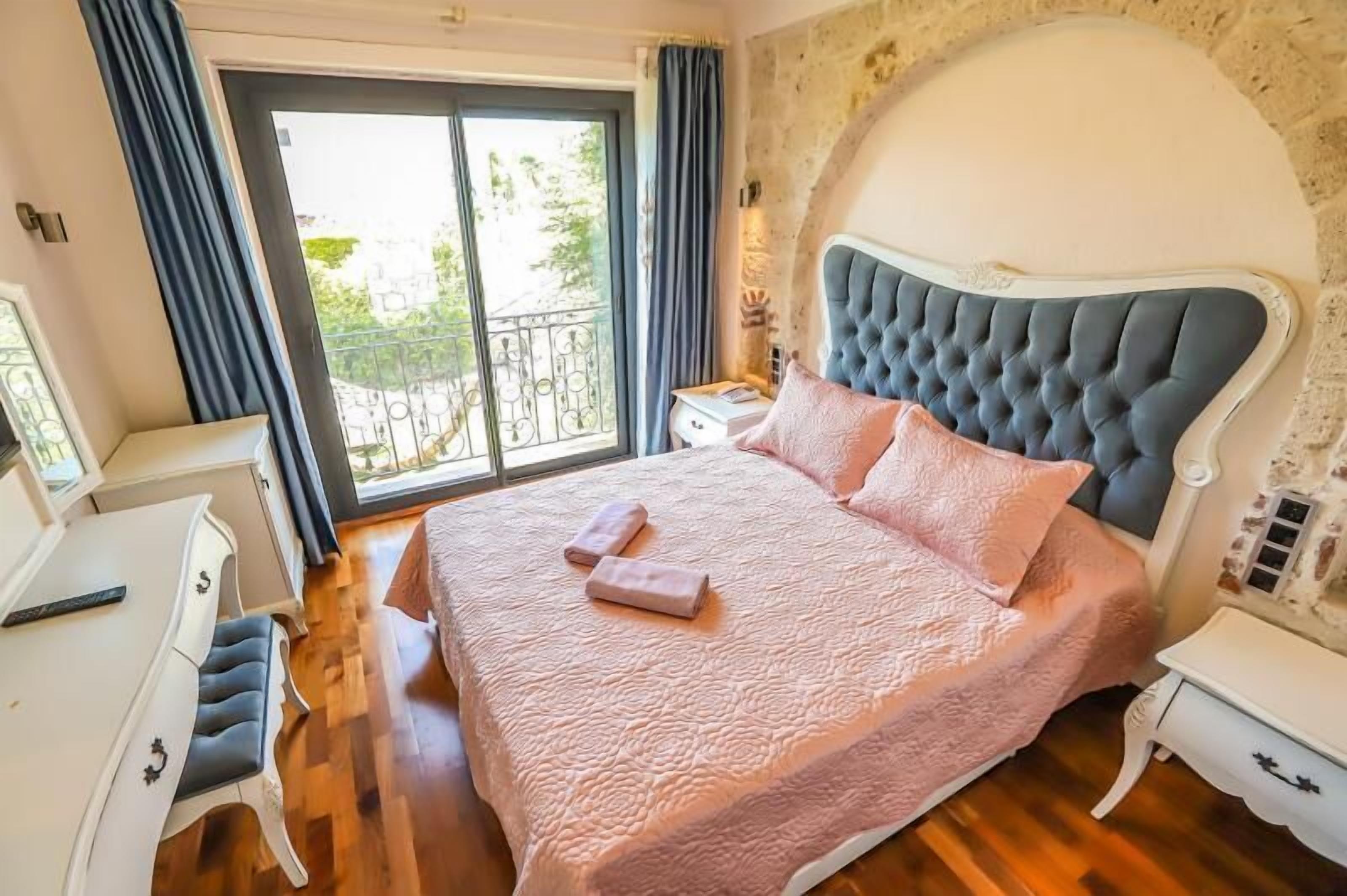 A bedroom with a large bed, a desk, and a chair.