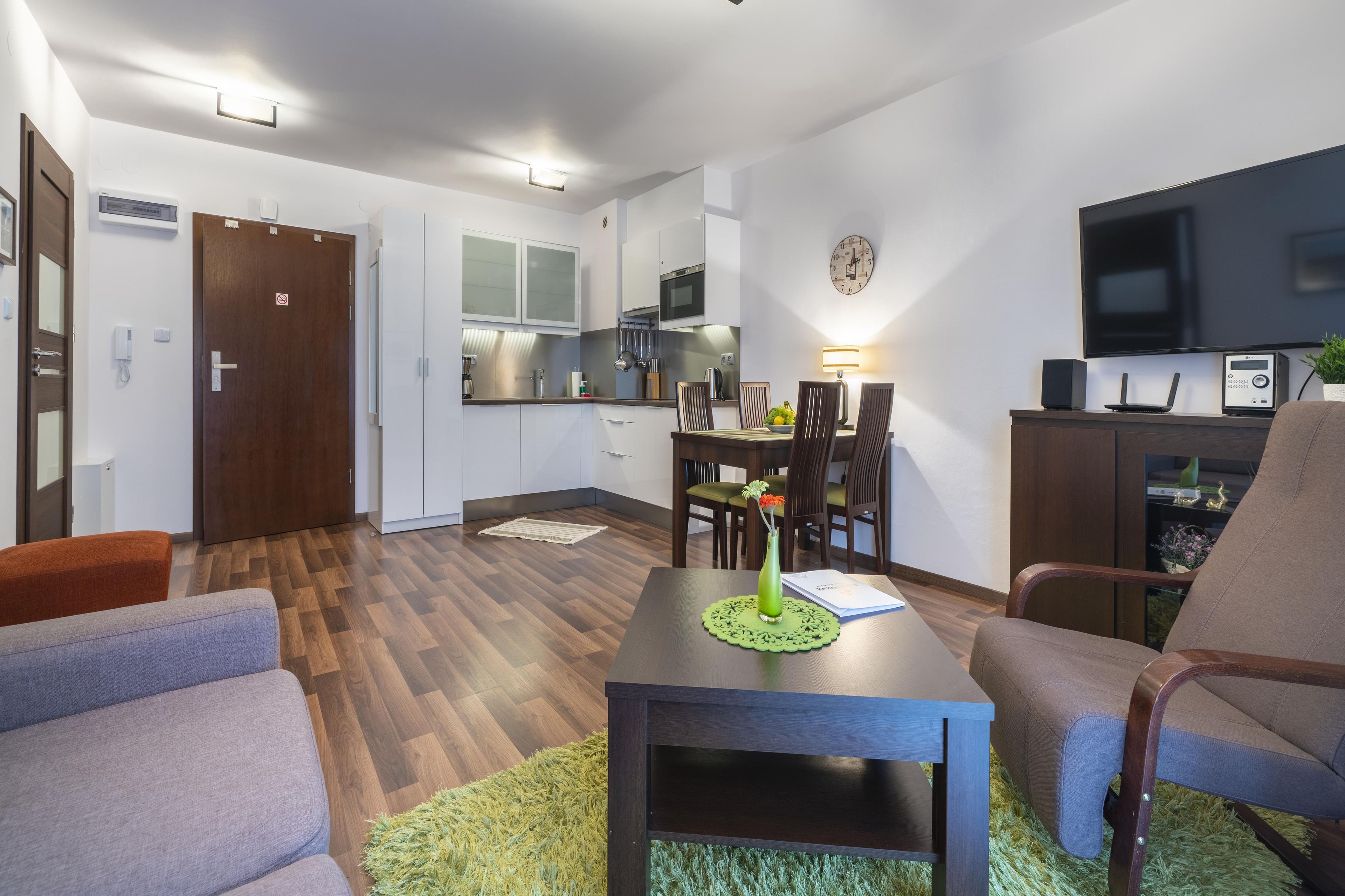 A modern apartment with a dining area, kitchen, and living room.