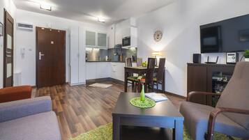 A modern apartment with a dining area, kitchen, and living room.