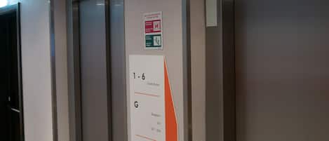 An elevator interior with a sign indicating guest rooms and parking.