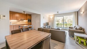 Un appartement moderne comprenant une cuisine, un coin repas et un salon.