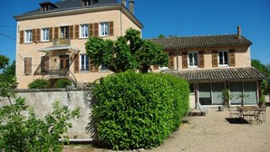 A two-story house with a balcony, a covered patio, and a well-maintained garden. - Le Clos des Tanneurs (Taponas)