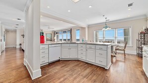 A spacious kitchen with white cabinetry, a large island, and a wooden floor. - DIRECT GULF FRONT LUXURY HOME, INCREDIBLE BEACHES, SPACIOUS LAYOUT. (Gulf Shores)