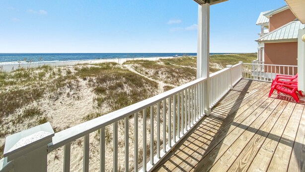 A wooden deck with a white railing overlooking a beach with dunes and the ocean. - DIRECT GULF FRONT LUXURY HOME, INCREDIBLE BEACHES, SPACIOUS LAYOUT. (Gulf Shores)