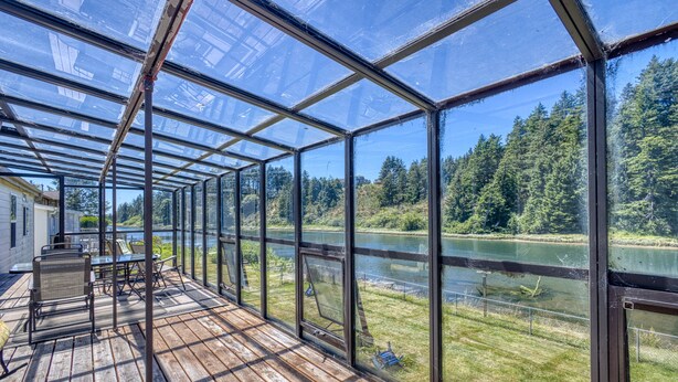 Una terrazza riparata con vista su un fiume e una foresta.