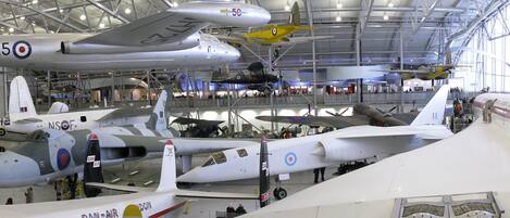 Una extensa exhibición en interiores de varias aeronaves militares, incluyendo aviones con marcas como “DAN AIR” y “5C”.