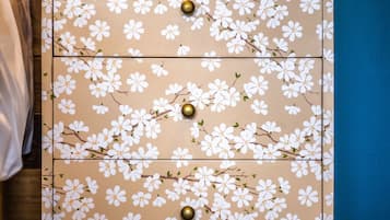 Un aparador de madera con motivos florales y pomos de latón, sobre un piso alfombrado.