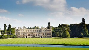 A large, historic building with a symmetrical facade, a central entrance, and a well-maintained lawn in front. - The Cricketers (Saffron Walden)