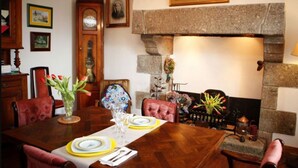 Un comedor con una mesa de madera dispuesta para cuatro personas, rodeada de sillas tapizadas en rojo.
