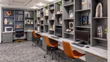 A modern office space with long desks, comfortable chairs, and decorative shelves.