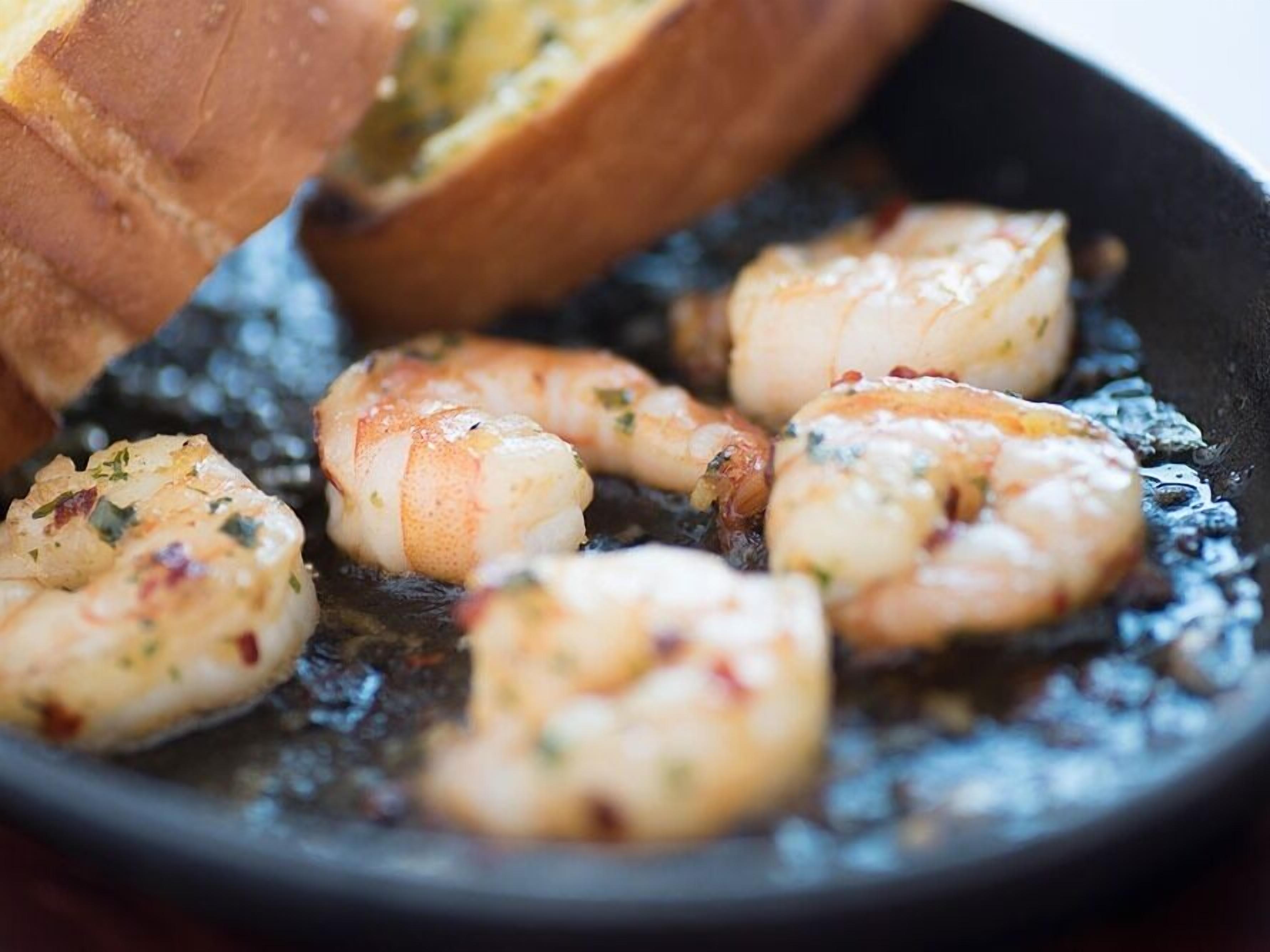 Una sartén con camarones que se cocinan.
