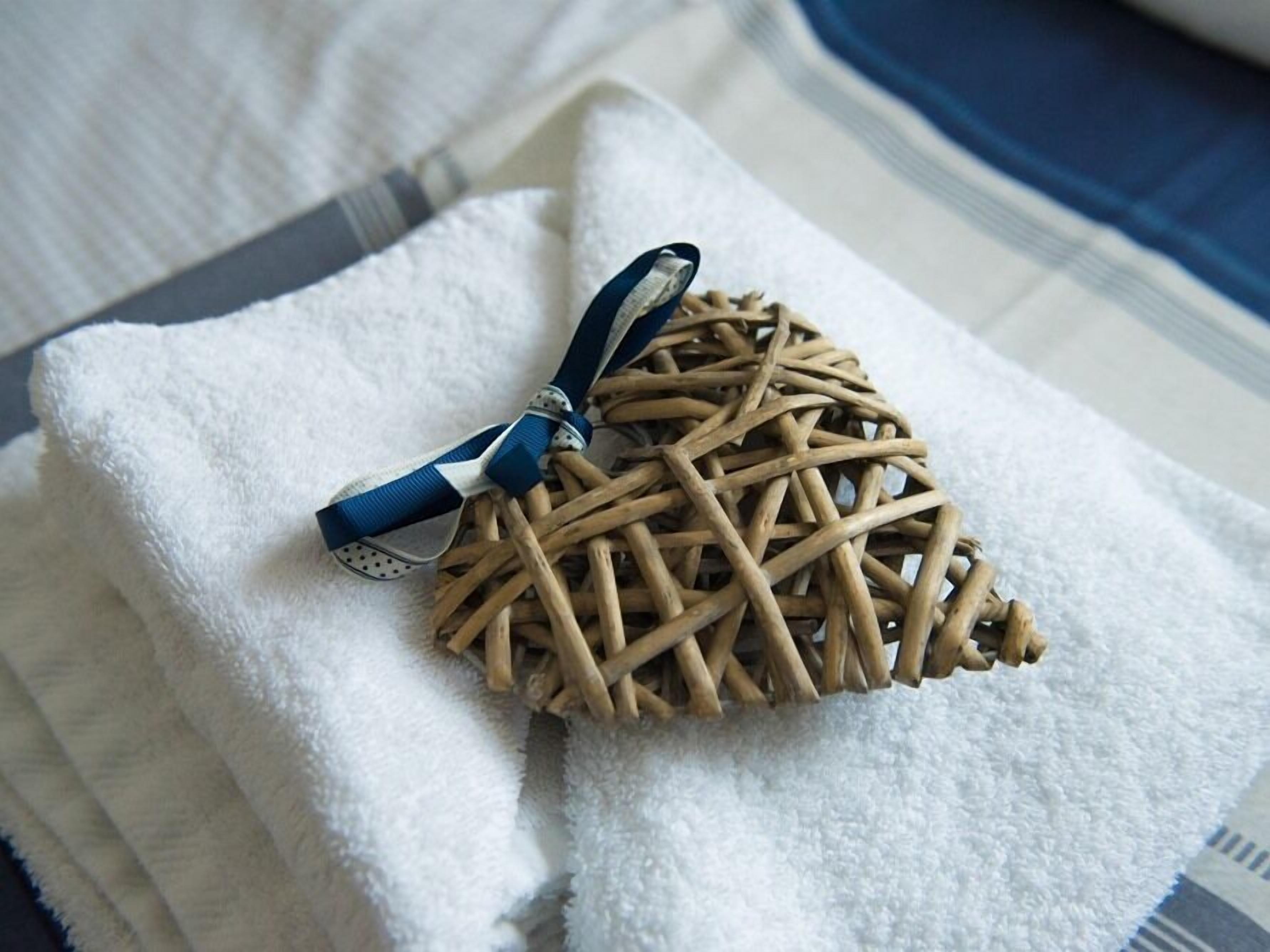 A woven basket tied with a blue ribbon, placed on a white towel.