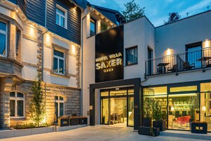 Ein Hotel mit moderner Fassade, einer markanten Beschilderung und einem gut beleuchteten Eingang.
