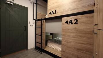 A room with bunk beds labeled A1 and A2, a ladder, and a green door.