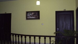 A hallway with a light fixture, a framed picture, and doors numbered 15 and 16. - Margalla Lodge (Islamabad)