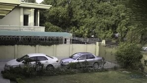 A residential area with two parked cars, a house with a balcony, and a tree. - Margalla Lodge (Islamabad)