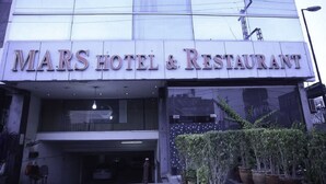 Het uiterlijk van MARS HOTEL & RESTAURANT, met een grote glazen gevel en een bord boven de ingang.