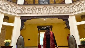Un atrio de varios niveles con barandillas ornamentales y una escalera central.