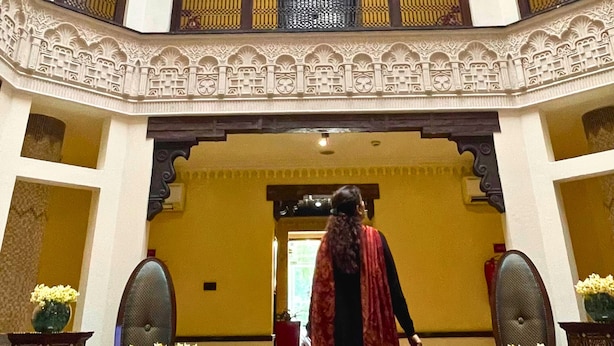 Ein mehrgeschossiges Atrium mit aufwendiger Geländerarbeiten und einer zentralen Treppe.