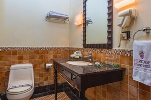 A bathroom with a toilet, sink, and towel rack.