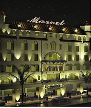 A multi-story hotel with a classic architectural style, featuring arched windows and balconies. - Marvel Hotel (Lahore)