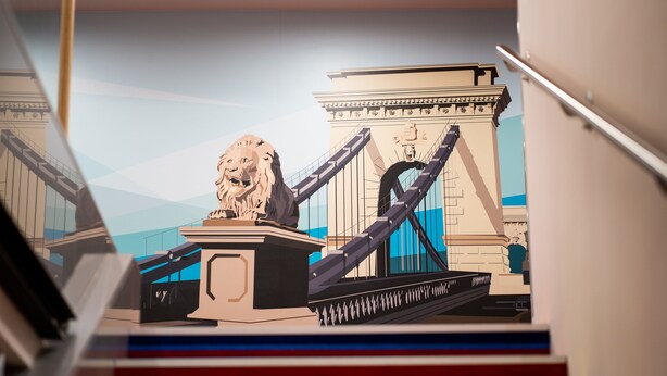 A staircase with a lion statue and a bridge in the background. - Ibis Styles Budapest Citywest (Budapest)