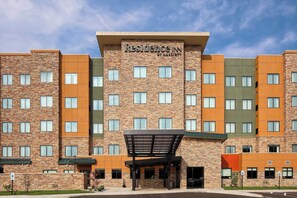 Experience the contemporary design of Residence Inn, featuring a covered entrance and multiple windows for ample natural light.