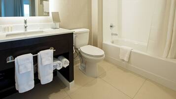 A modern bathroom with a sink, toilet, and bathtub.