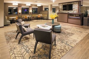 Relax in comfort with sofas, chairs, and a round table in our inviting lobby, featuring a flat-screen TV and a cozy fire feature.