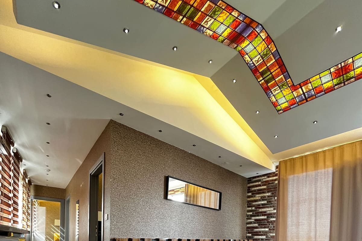 A modern living room with a sofa, a coffee table, and a large mirror on the wall.