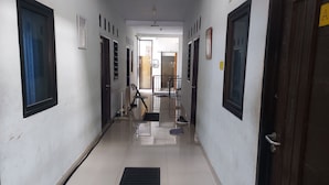 Un pasillo con puertas a ambos lados, un pasillo central y una puerta visible al final.