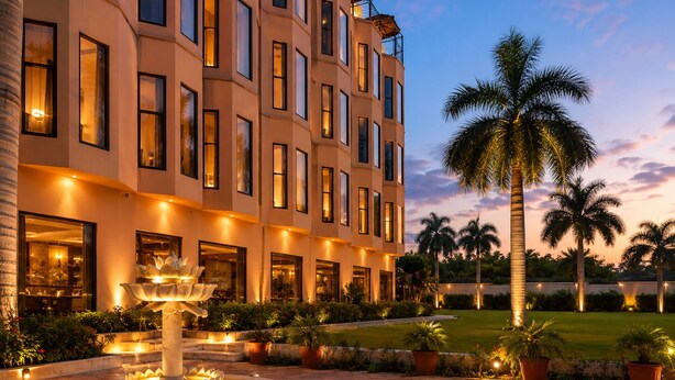 A multi-story hotel with a courtyard, palm trees, and a fountain.