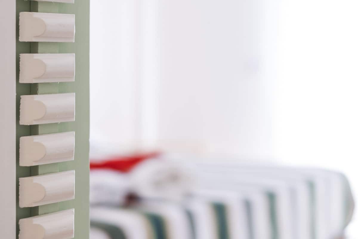 A bed with a striped bedding and a green headboard.